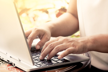Businesswoman hand typing on laptop keyboard in the coffee shop,