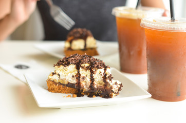 Woman's hand about to cut the cake with iced tea drink phot