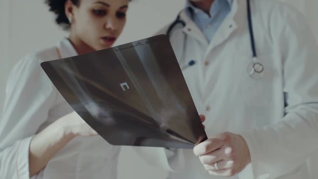 Healthcare, medical: Doctors discuss and looking x-ray in a clinic or hospital. Close up. UHD 4K