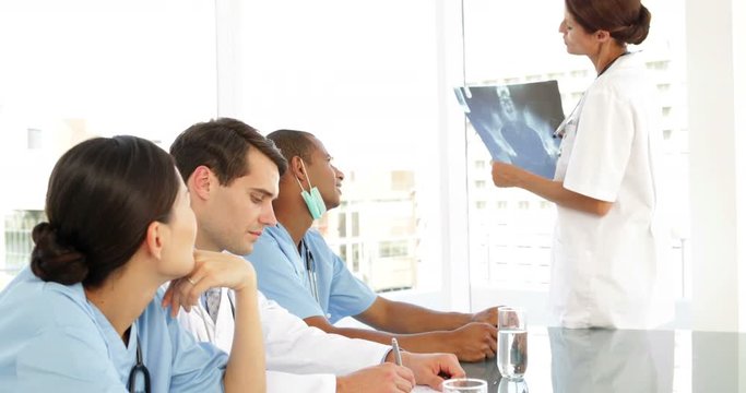 Medical team talking during a meeting looking at xray