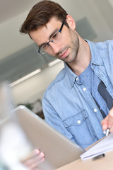 Naklejka premium man at home working on digital tablet