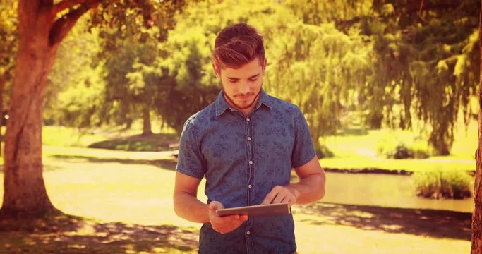 Handsome man using tablet in the park