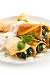 Crepes with spinach and feta cheese on white background 