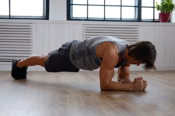 Male doing stomach exercising on a floor.