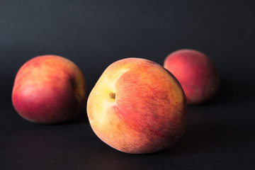 Fototapeta na wymiar Close up shot of fresh peaches on a black background
