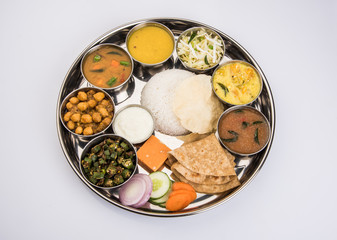 indian thali, indian food thali, punjabi thali, punjabi food thali, north indian thali, roti, gulab jamum, paneer, chole, pulav or veg biryani, raita or rayta, daal tadka or tarka combination © StockImageFactory