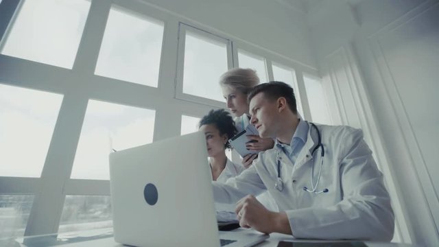 Healthcare, medical: Group of multi-ethnic doctors discuss and looking x-ray in a clinic or hospital. UHD 4K