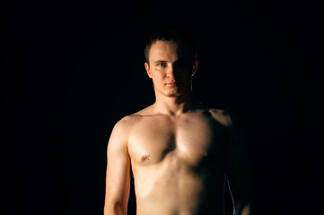 Naklejka premium Torso of strong man against dark background