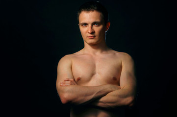 Fototapeta premium Torso of strong man against dark background