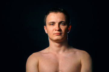 Fototapeta premium portrait of topless athletic man posing over black background