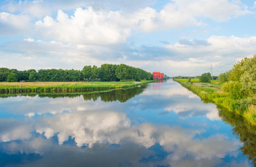 Reflection of clouds in a canal in summer