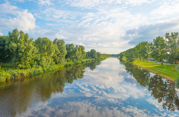Reflection of clouds in a canal in summer