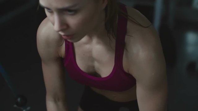 Fitness girl using cable crossover machine while working out in the gym
