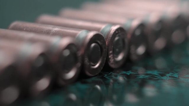 Row of new, not shooting bullet caliber 9mm on reflective surface. Closeup. Color correction