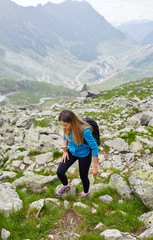 Naklejka na ściany i meble Woman backpacker hiking on a trail
