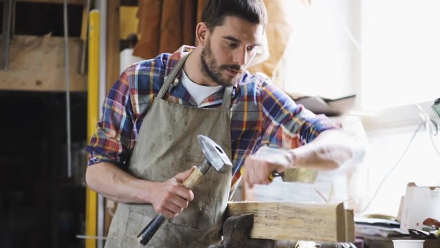 carpenter with chisel working at workshop