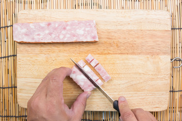 chef cutting bacon for cooking fired rice