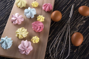 Board of homemade pastel colored meringue cookies.
