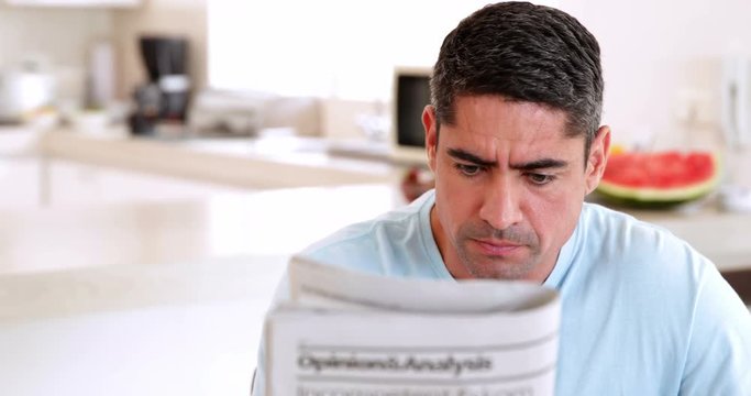 Man reading newspaper and having coffee in the morning