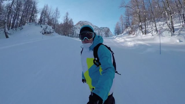 SELFIE: Snowboarding down the ski slope in sunny winter