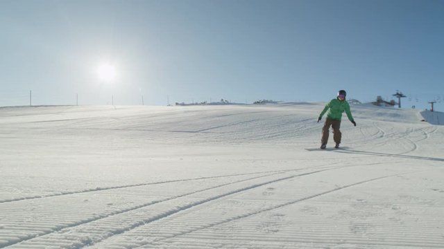 SLOW MOTION CLOSEUP: Race snowboarder carving on perfect snow