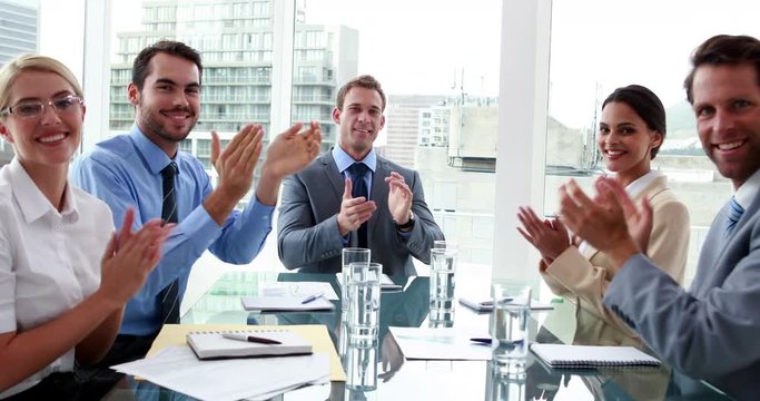 Business people clapping at camera in board room in the office