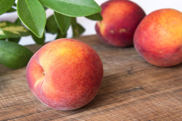Fototapeta na wymiar Fresh peaches on a wooden cutting board.