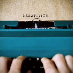 man typewriting the word creativity