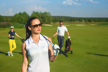 Portrait of young sportive women golfer playing golf with friends at sunny day