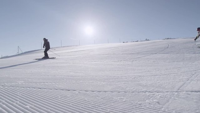 SLOW MOTION: Skiing on perfectly groomed snow in mountain resort