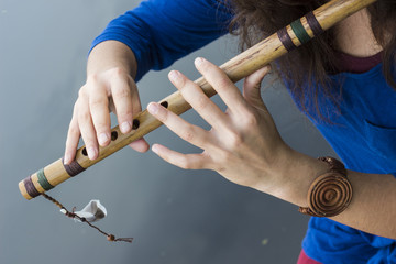 Musician playing a wooden flute on the banks of the river © afanasyeva_t
