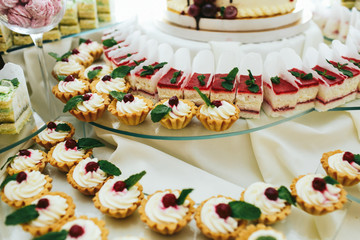 White pastry stand on glass plated on a dinner table