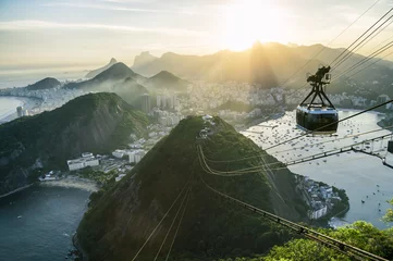 Fotobehang Helder mistig uitzicht op de skyline van de stad van Rio de Janeiro, Brazilië met een Sugarloaf (Pao de Acucar) bergkabelbaan die op de voorgrond passeert © lazyllama
