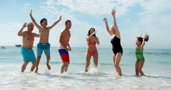 Happy Extended Family Jumping On The Beach