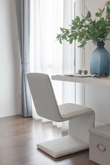 modern white chair in working space with vase of flower