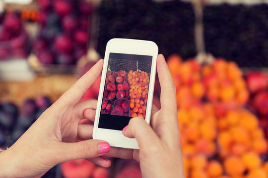 hands with smartphone taking picture of fruits