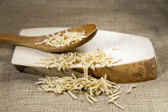 Organic raw homemade Macaroni over wooden tray and sackcloth, studio image