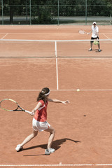 Junior female tennis player working with her coach