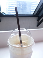 a half of offee next to windows wall