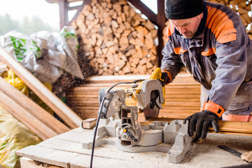 Carpenter working. Man cutting plank by circular saw.