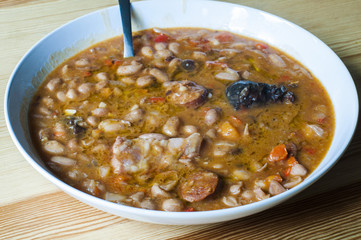 Spanish red beans stew with sausages, bacon and vegetables