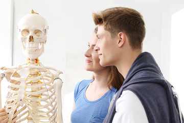 Szkoła, lekcja anatomii uczniowie oglądają model szkieletu