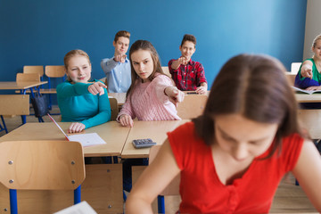 students gossiping behind classmate back at school