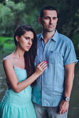Obraz premium Sad couple standing by the river and looking far