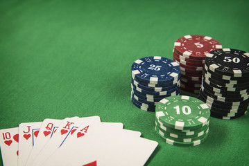 Gambling chips and poker card on green felt background