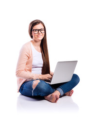 Naklejka premium Woman with laptop sitting on the floor, studio shot, isolated