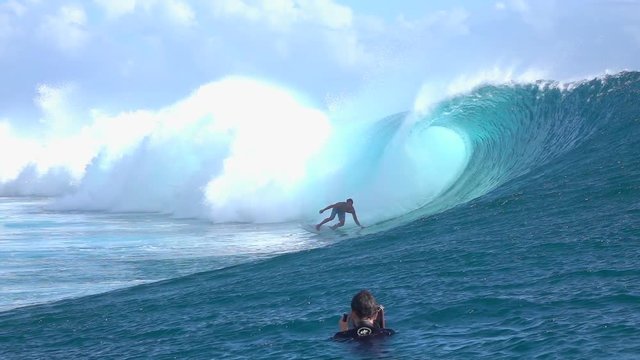 SLOW MOTION: Photographer filming surfer surfing big tube barrel wave