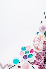 Workspace. Brushes, palette, bouquet of lilac isolated on white background. flat lay, overhead view, top view