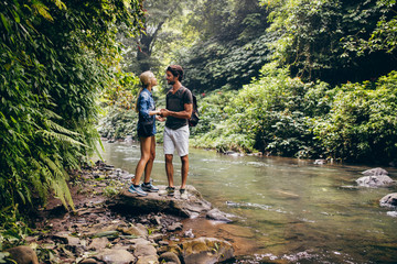 Obraz premium Loving couple standing by a mountain stream