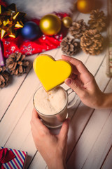 female hands holding a cookie and cup of coffee